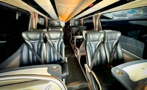 VIP team coach interior showing spacious leather seats with tables for all passengers